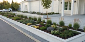 A stunning front yard flower bed idea with a modern design and layered colorful plants.